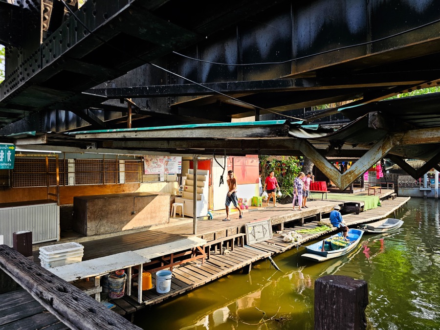 A canal-side scene beneath a bridge in Thailand