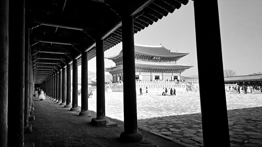 A traditional palace viewed through a column-lined corridor in Seoul