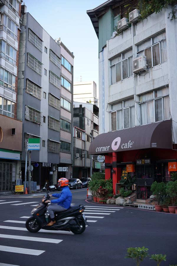 A street corner in Taiwan with a passing scooter